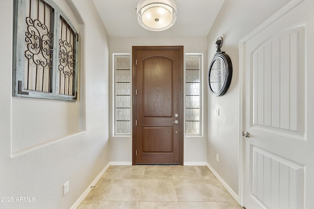 entrance foyer featuring light tile patterned floors and baseboards