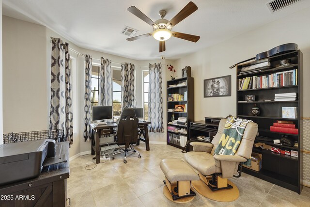 office space featuring a ceiling fan, visible vents, baseboards, and light tile patterned floors