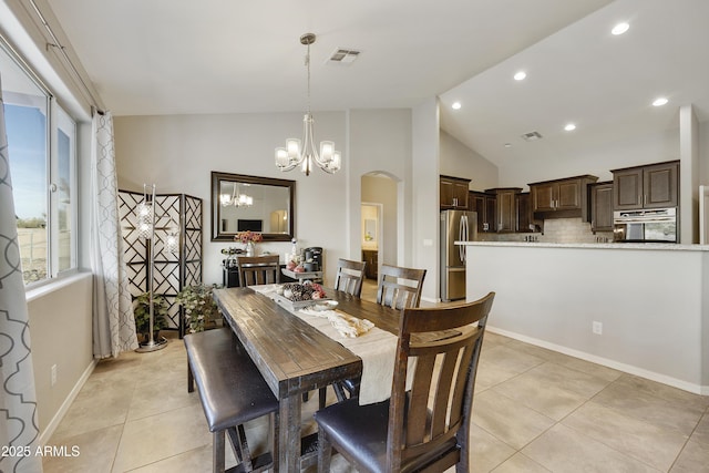 dining space featuring visible vents, arched walkways, a notable chandelier, and light tile patterned flooring