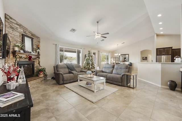 living room featuring a fireplace, ceiling fan with notable chandelier, vaulted ceiling, and light tile patterned floors