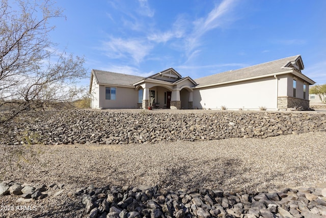 view of front facade with stone siding and stucco siding