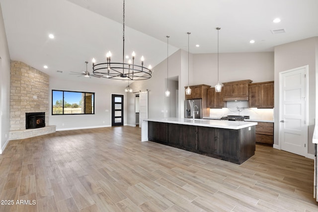 5630 E Norma Dr, Prescott Valley, AZ 86315 - kitchen with stainless steel fridge, light countertops, high vaulted ceiling, a chandelier, and a stone fireplace