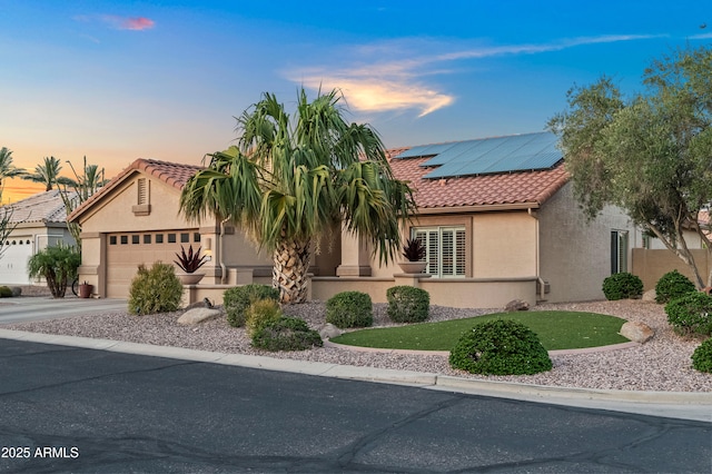 4029 N 160th Dr, Goodyear, AZ 85395 - view of front of house featuring a tiled roof, stucco siding, roof mounted solar panels, concrete driveway, and an attached garage