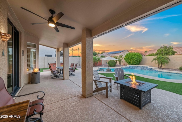 4029 N 160th Dr, Goodyear, AZ 85395 - patio terrace at dusk featuring an outdoor fire pit, a patio, a fenced backyard, and a ceiling fan