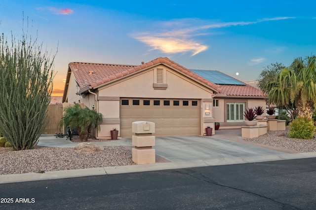 4029 N 160th Dr, Goodyear, AZ 85395 - view of front of house featuring a garage, roof mounted solar panels, stucco siding, and a tile roof
