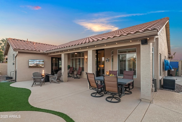 4029 N 160th Dr, Goodyear, AZ 85395 - back of property at dusk with a patio area, a tiled roof, and stucco siding