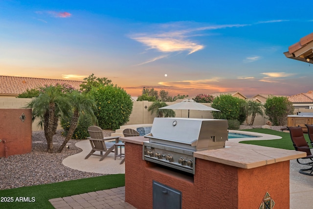 4029 N 160th Dr, Goodyear, AZ 85395 - patio terrace at dusk with area for grilling, a patio, and a fenced backyard