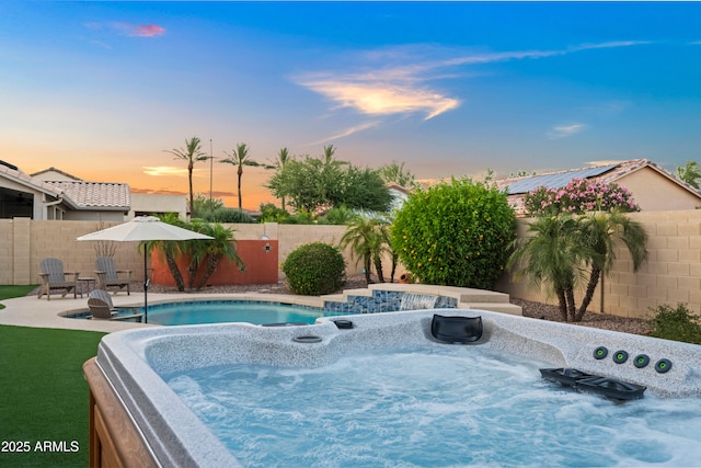 4029 N 160th Dr, Goodyear, AZ 85395 - pool at dusk featuring a fenced backyard, a hot tub, and a patio