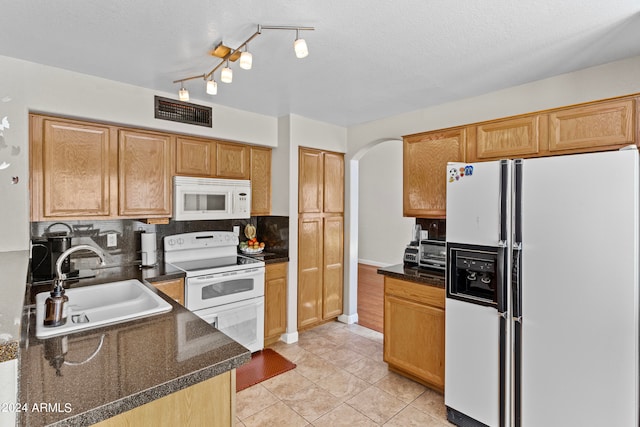 kitchen with white appliances, sink, decorative backsplash, light tile patterned floors, and a textured ceiling