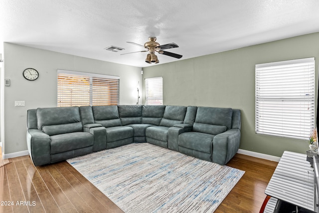 living room with ceiling fan, a textured ceiling, and hardwood / wood-style flooring