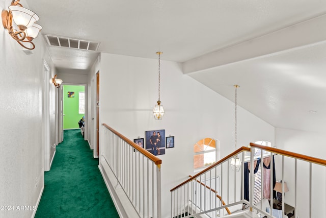 hall featuring dark colored carpet and lofted ceiling with beams