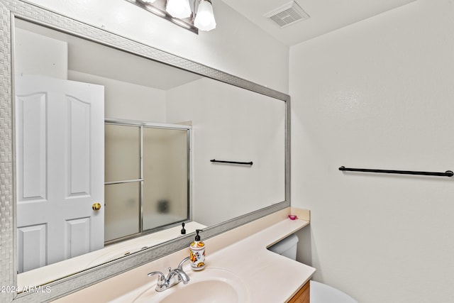 bathroom featuring vanity and an enclosed shower