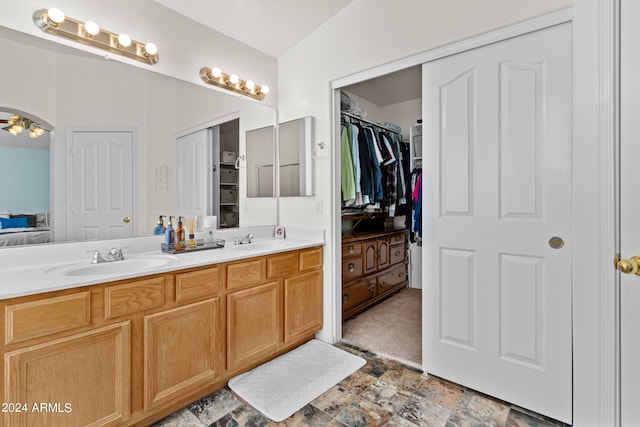 bathroom featuring vanity, vaulted ceiling, and ceiling fan