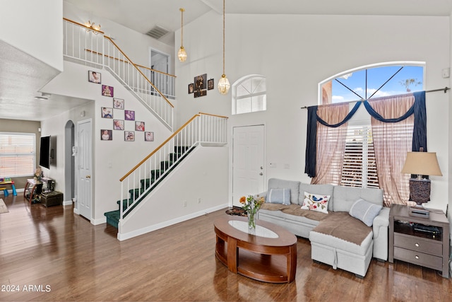 living room featuring high vaulted ceiling, plenty of natural light, and dark wood-type flooring