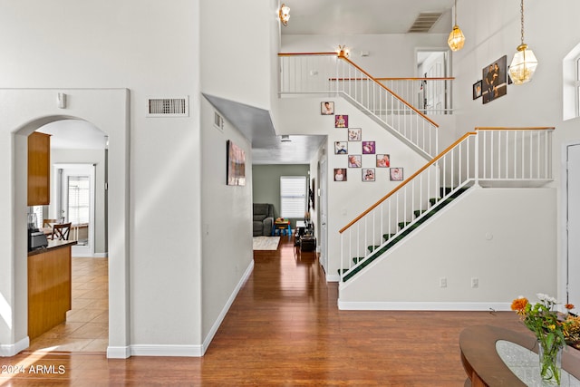 foyer featuring hardwood / wood-style floors, plenty of natural light, and a high ceiling