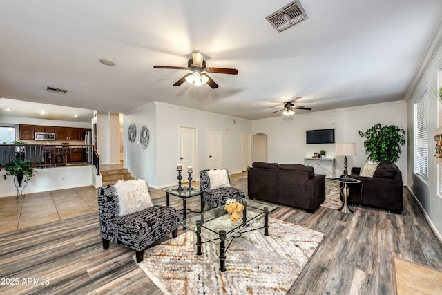 living room featuring ceiling fan, ornamental molding, and hardwood / wood-style floors