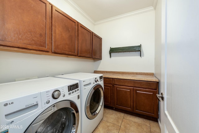 clothes washing area with light tile patterned floors, washing machine and dryer, ornamental molding, and cabinets