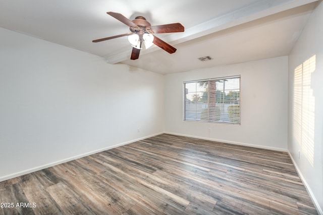 spare room featuring ceiling fan, dark hardwood / wood-style flooring, and beam ceiling