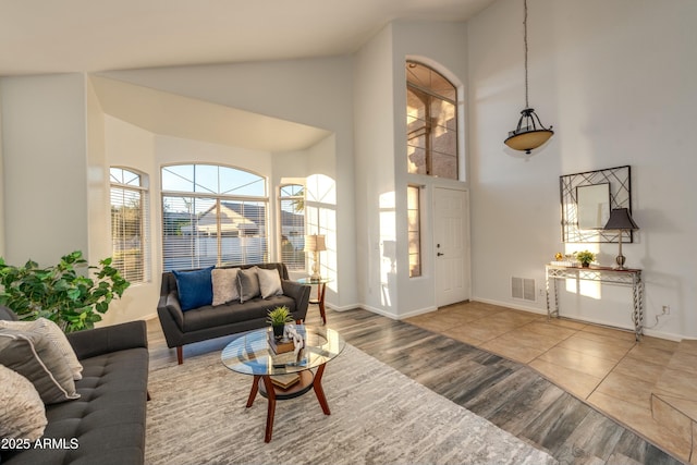 living room with hardwood / wood-style flooring and a towering ceiling