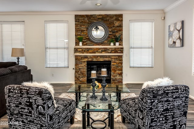 living room featuring ceiling fan, a stone fireplace, ornamental molding, and hardwood / wood-style flooring