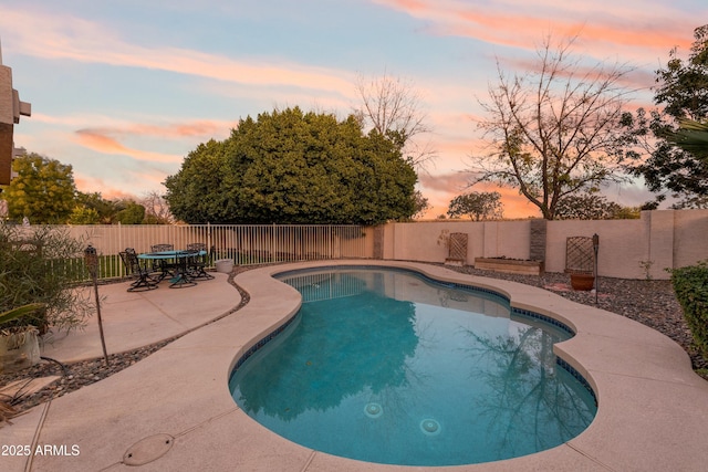 pool at dusk with a patio