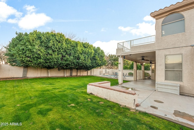 view of yard with ceiling fan, a pool, a patio area, and a balcony