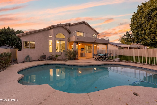 pool at dusk with a patio