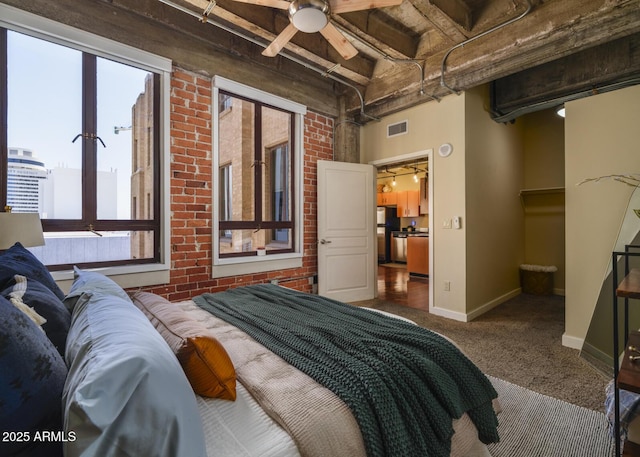 114 W Adams St Unit 907, Phoenix, AZ 85003 - carpeted bedroom with baseboards, freestanding refrigerator, and brick wall