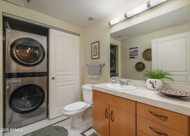 114 W Adams St Unit 907, Phoenix, AZ 85003 - bathroom featuring stacked washer and clothes dryer, vanity, toilet, and tile patterned floors