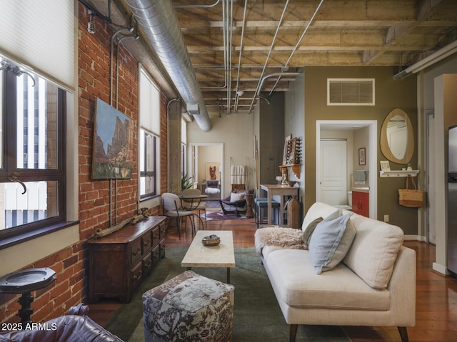 114 W Adams St Unit 907, Phoenix, AZ 85003 - living room featuring brick wall, wood finished floors, a towering ceiling, and baseboards