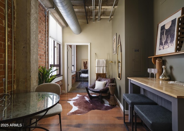 114 W Adams St Unit 907, Phoenix, AZ 85003 - hallway with a towering ceiling, brick wall, wood finished floors, and electric panel