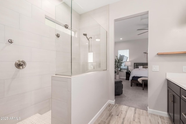 bathroom featuring vanity, baseboards, connected bathroom, a walk in shower, and wood finished floors