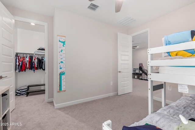 bedroom featuring a closet, visible vents, light colored carpet, and baseboards