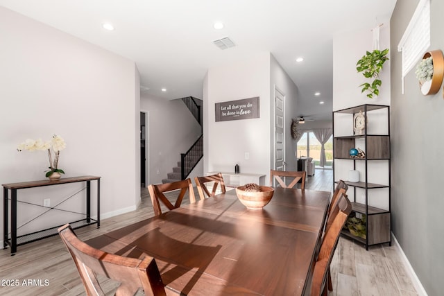 dining room with visible vents, baseboards, light wood-style floors, and stairs