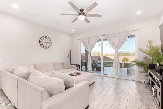 living room with visible vents, light wood-type flooring, a ceiling fan, and recessed lighting