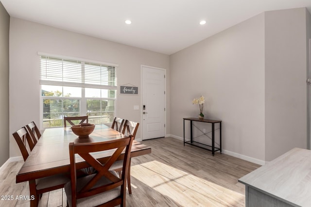 dining room featuring baseboards, light wood finished floors, and recessed lighting