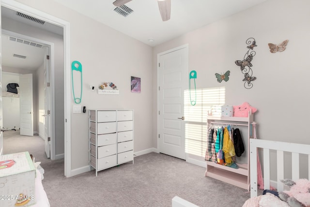 carpeted bedroom featuring a crib, visible vents, and baseboards