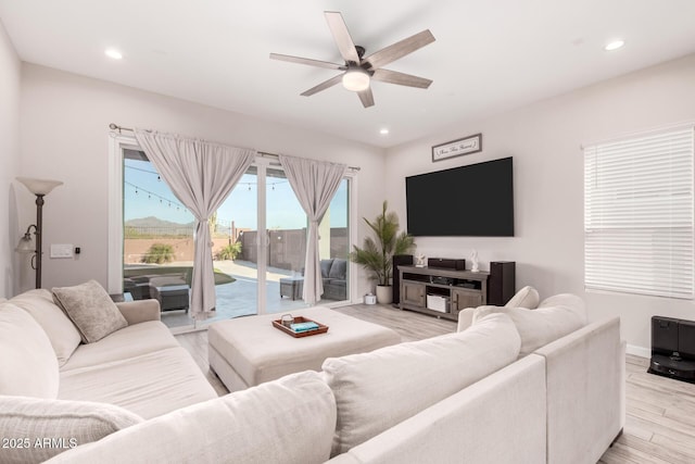 living area featuring light wood-style floors, baseboards, a ceiling fan, and recessed lighting