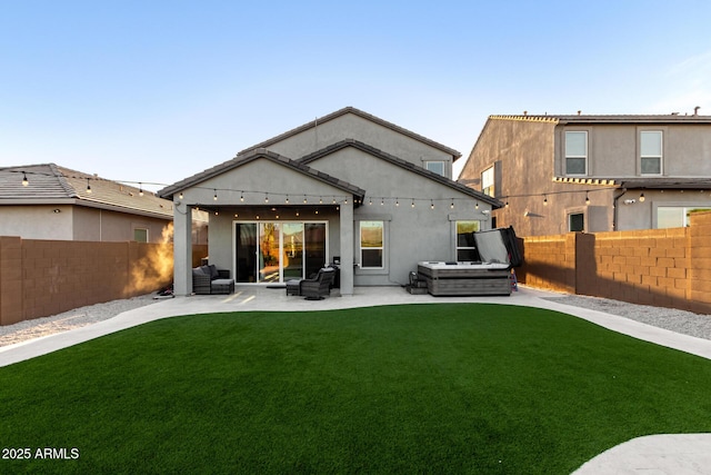 back of property with a patio, a fenced backyard, stucco siding, and a lawn