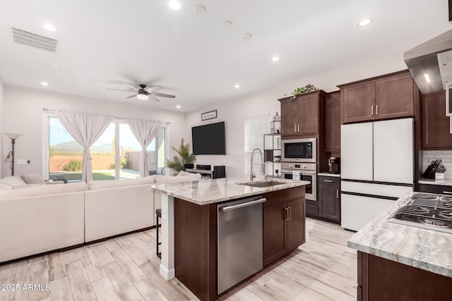 kitchen featuring ceiling fan, visible vents, a sink, stainless steel appliances, and open floor plan
