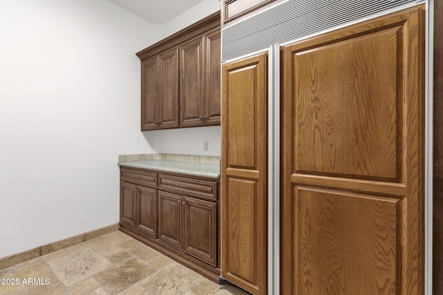 interior space with stone finish floor, light countertops, and baseboards