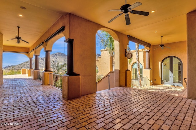 view of patio featuring a mountain view, a ceiling fan, and french doors