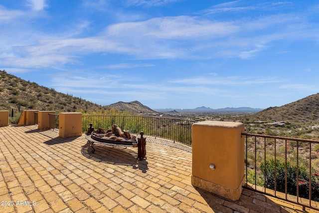 view of patio with a fire pit and a mountain view