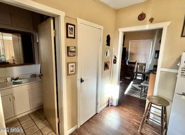 hallway with sink and light hardwood / wood-style flooring