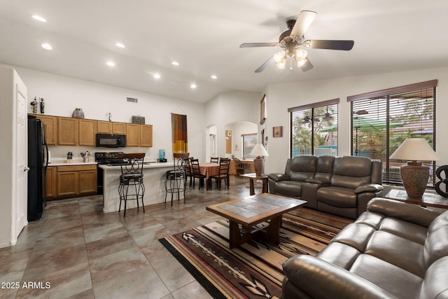 living room featuring vaulted ceiling and ceiling fan