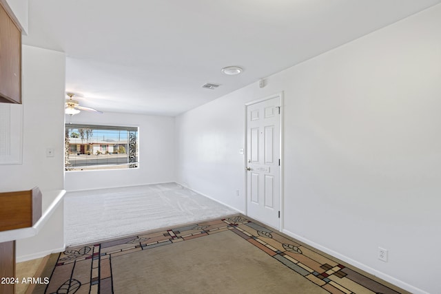 carpeted spare room with ceiling fan