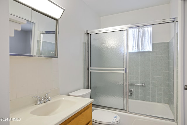 full bathroom with vanity, shower / bath combination with glass door, toilet, and tasteful backsplash