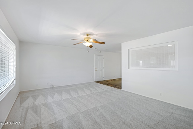 spare room with ceiling fan and light colored carpet