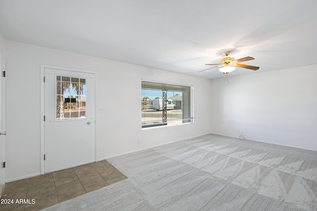 carpeted empty room featuring ceiling fan and a wealth of natural light