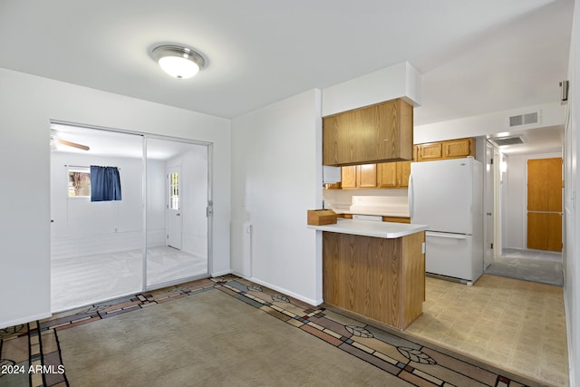 kitchen with kitchen peninsula and white fridge